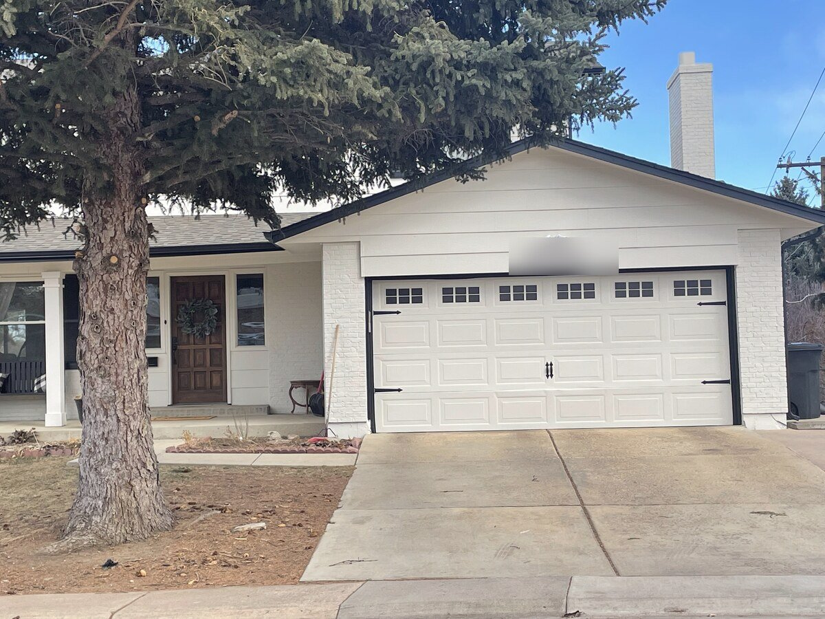 White carriage-style garage door with top windows after panel replacement and repair in Centennial